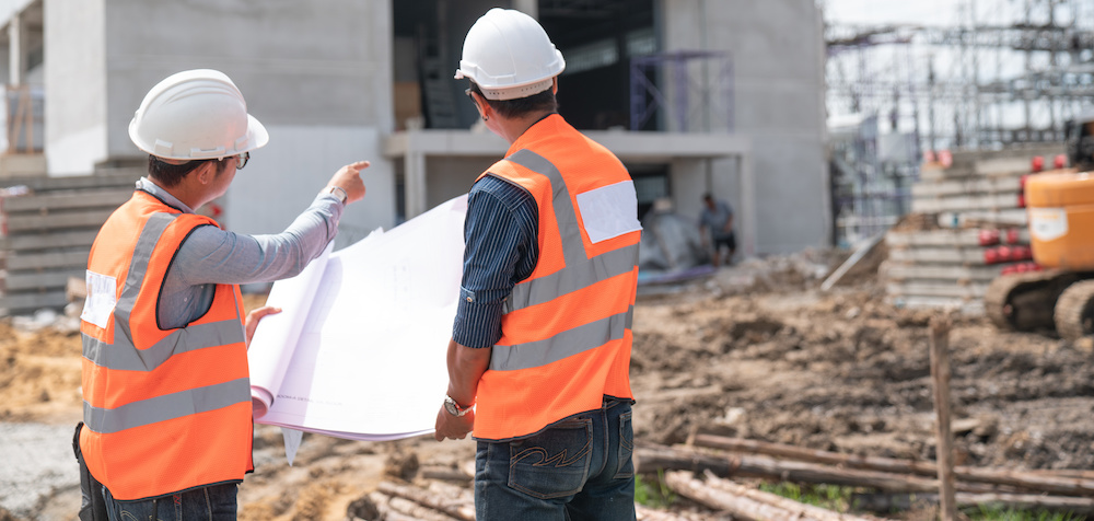 Construction engineers discussion with architects at construction site